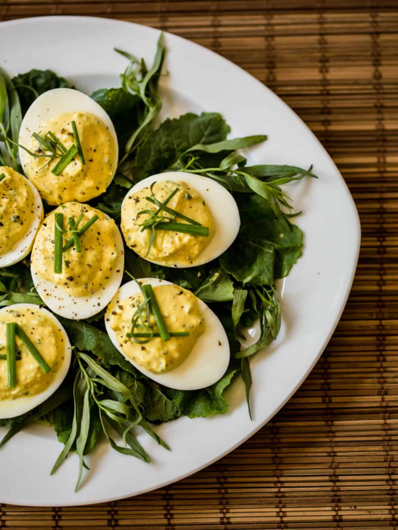 Horseradish Deviled Eggs on a plate garnished with fresh tarragon.