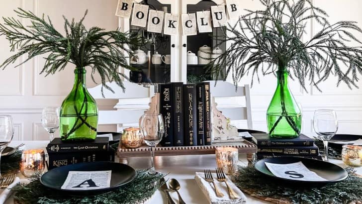 table decorating in a book theme large green glass bottles filled with greenery