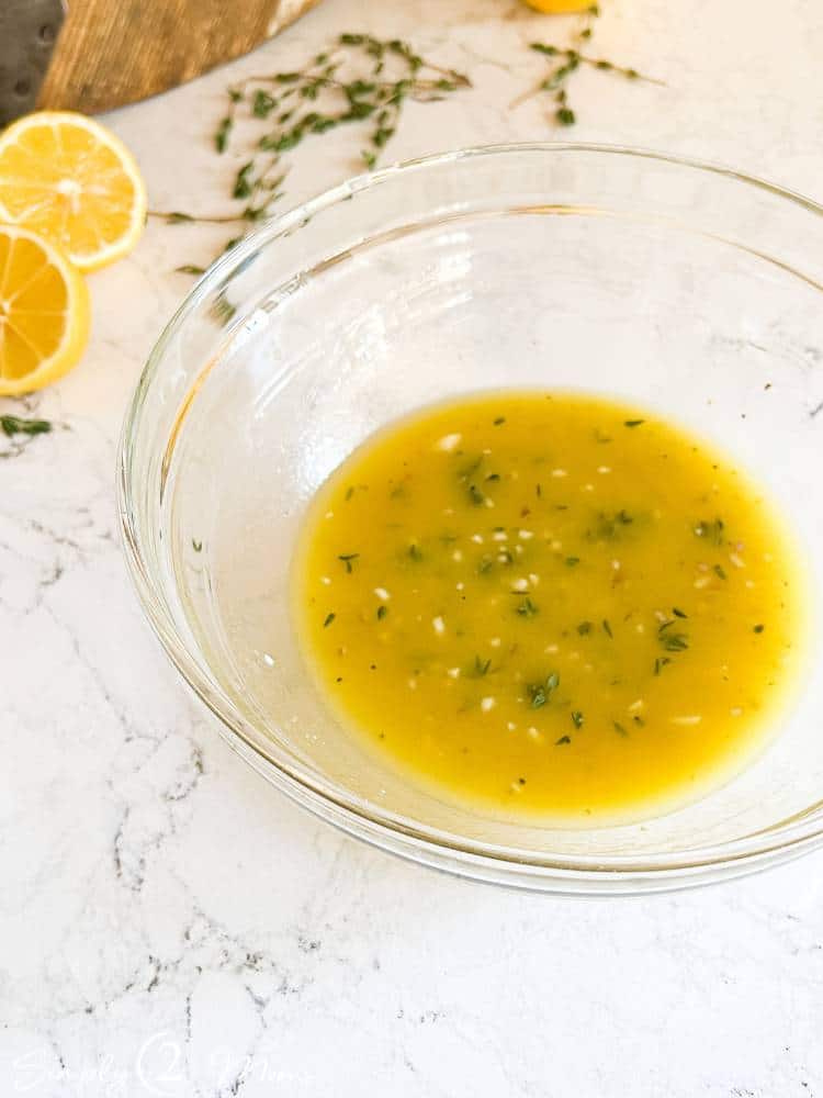 Clear glass bowl with fresh keto sweet lemon vinaigrette dressing.