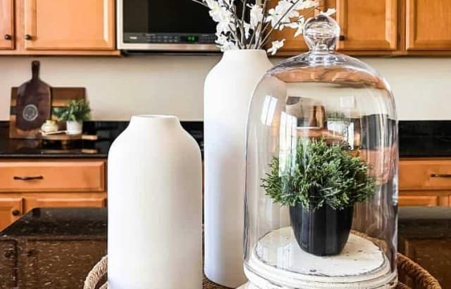 tray on kitchen island with vases and cloche