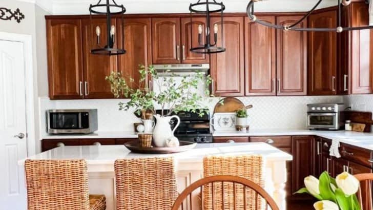 kitchen with cherry cabinets and black pendants over the island with seagrass stools