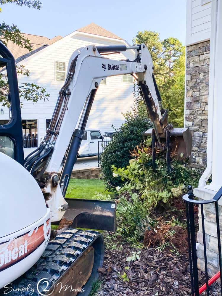 small excavator removing large bushes