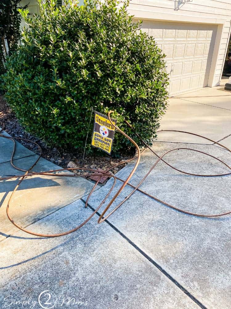 irrigation tubing pulled out of flower bed laying on driveway