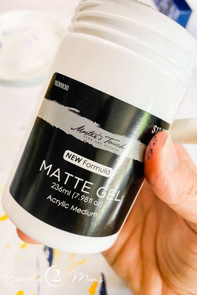 Bottle of matte gel acrylic medium in a woman's hand.