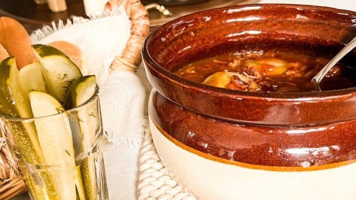 Vintage bean crock filled with baked beans with onions and bacon.