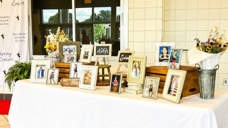 table set up with photos at varied heights and flowers for senior night display table feature