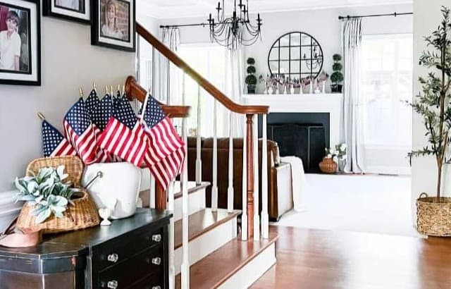 Open concept entry and family room decorated for summer with US flags in vintage containers.