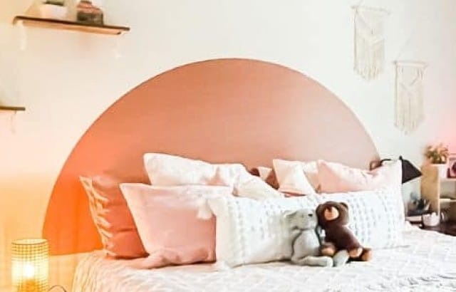 Small apartment bedroom decorated with boho style using vinyl decals, macrame shelves, and throw pillows.