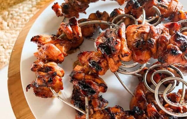 Plate with huli huli chicken kebabs on circular skewers for a tropical cocktail party.