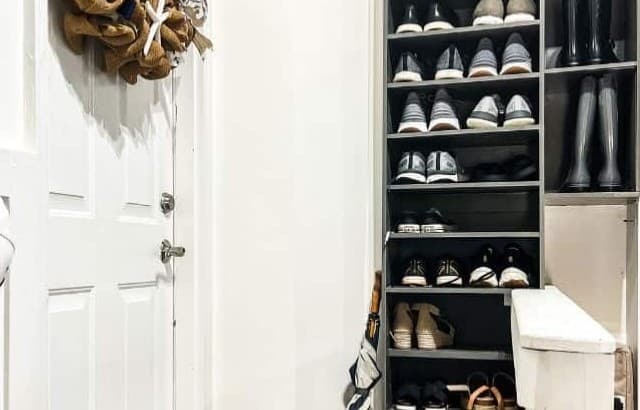 DIY shoe shelves built in on a wall in a garage landing next to the entrance door for the house.