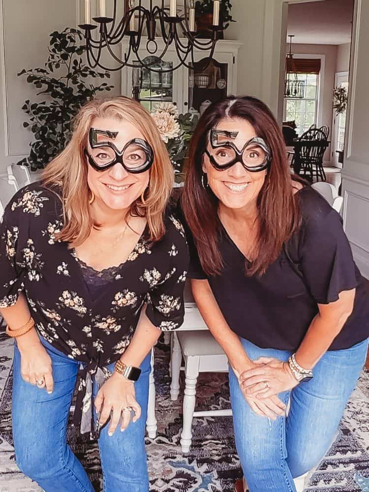 Anne and AnnMarie from Simply2Moms posing while wearing novelty glasses with the number 50.