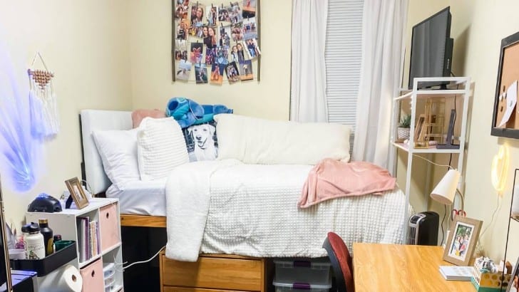 decorated girls dorm room with cozy bedding in white and pink color scheme