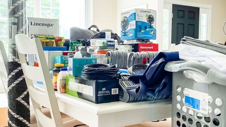 Table stacked with supplies for a boy's dorm room.