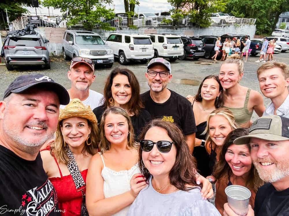 group of friends taking selfie in parking lot before concert