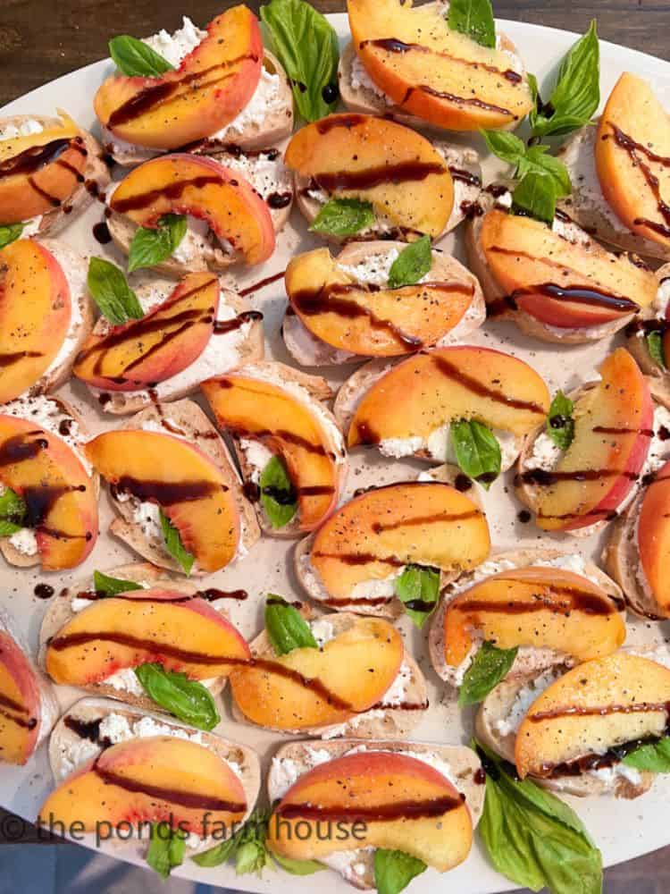 Plate of Peach Goat Cheese Bruschetta drizzled with balsamic glaze from The Ponds Farmhouse.