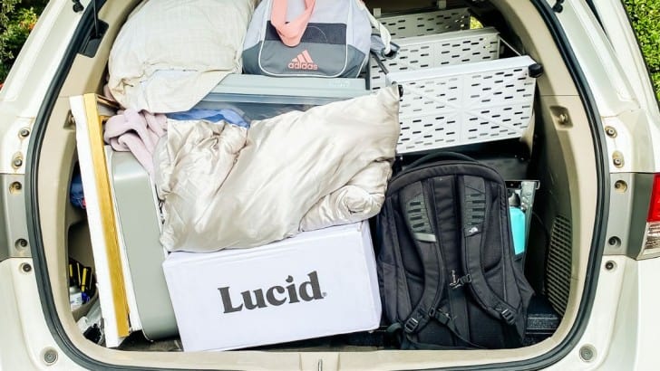 Mini van with the back hatch open to show the inside filled with everything to move into a college dorm.