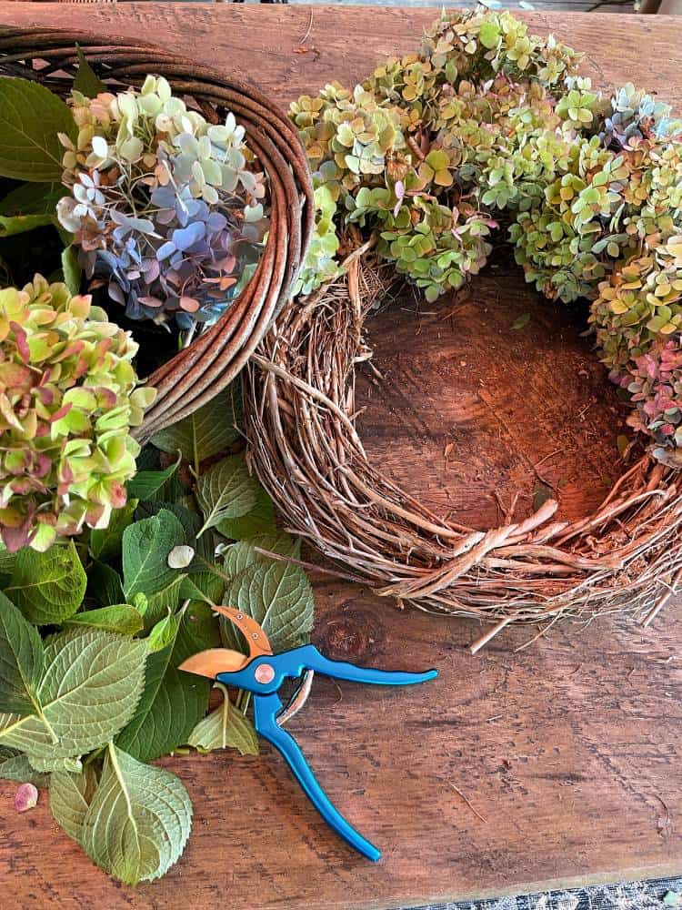 grapevine wreath with fresh cut hydrangea blooms on table