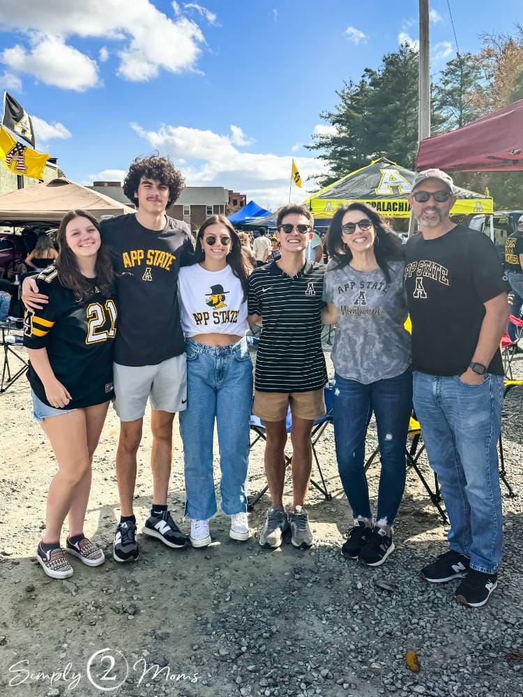 group of people standing together at college football game tailgate party