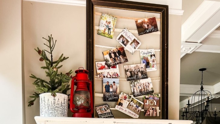 Large thrifted picture frame with ribbon attached in the opening to display holiday cards or photos.