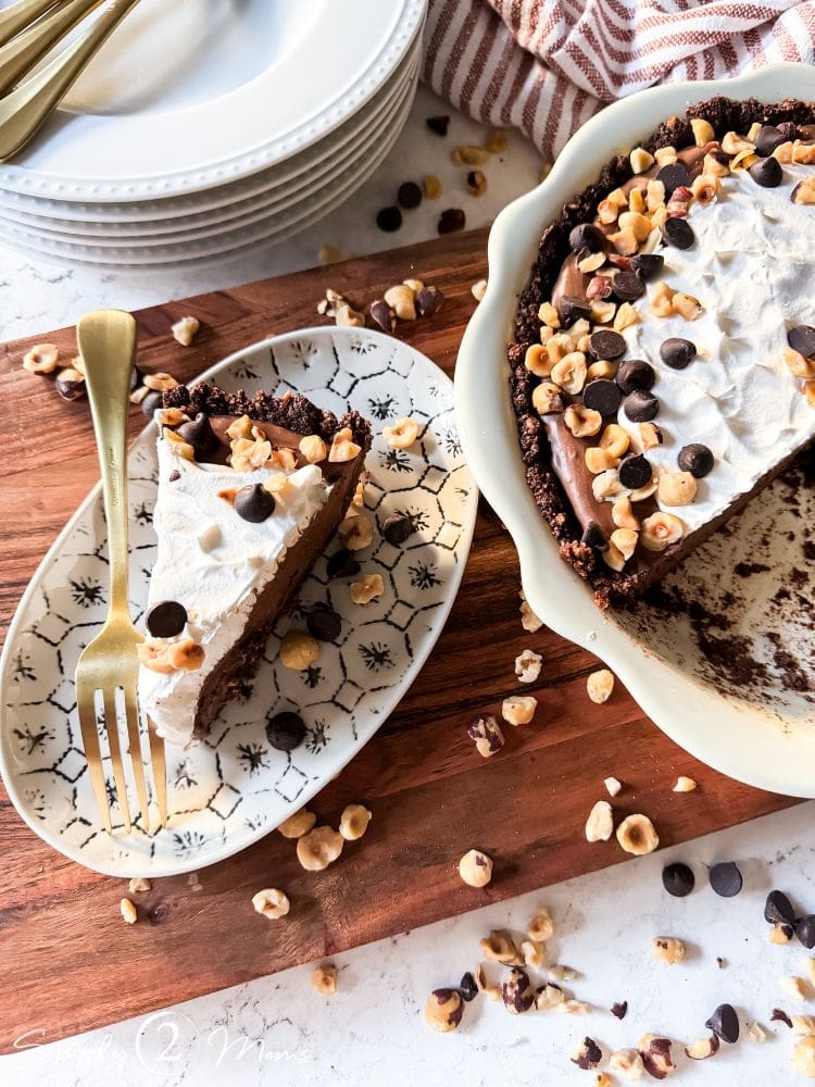 Slice of dairy free nutella pudding pie on a plate next to the pie.