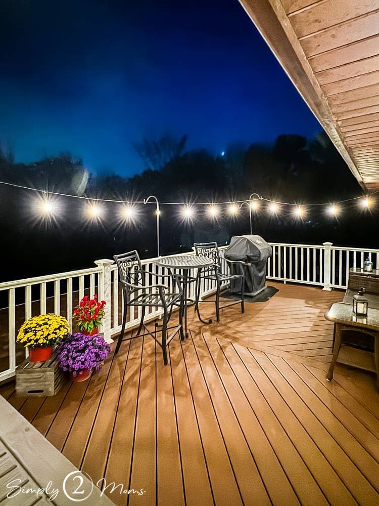 outdoor deck with string lights hanging around perimeter above railing