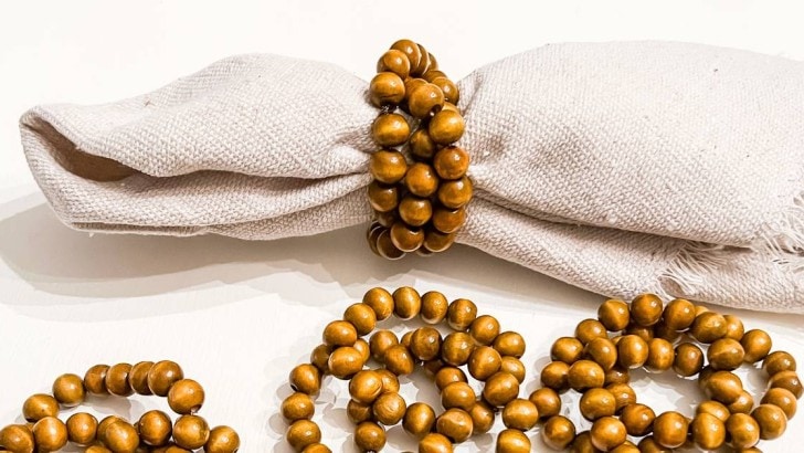 wood bead napkin rings on linen napkin with additional rings laying beside it feature photo