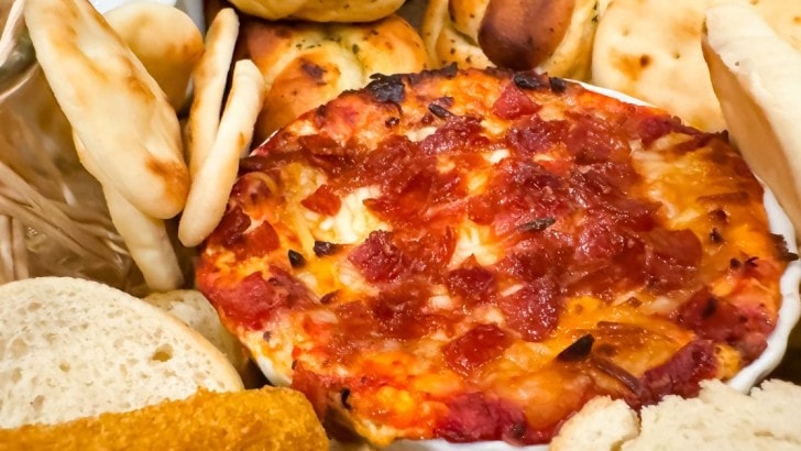 Hot pizza dip surrounded by bread for dipping.
