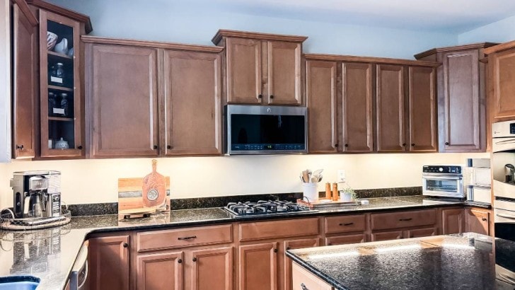 pulled back photo of kitchen cabinets with lighting for feature