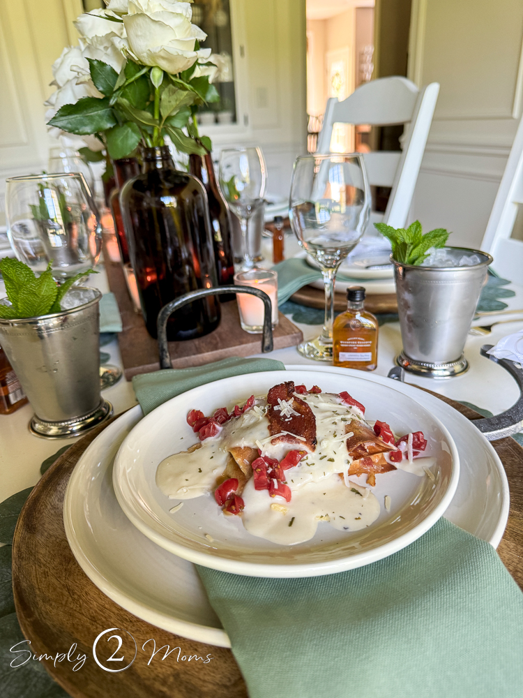 Dinner plate with Kentucky Hot Brown Sandwich stack on a table set for a Derby Day party.