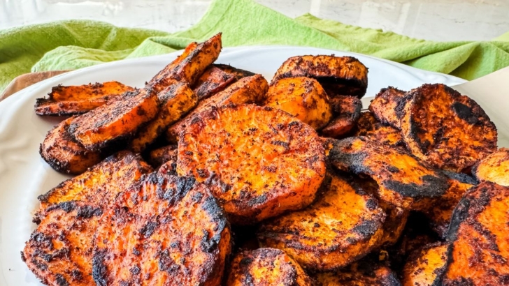 Plate of smoky grilled sweet potatoes with charred seasonings.