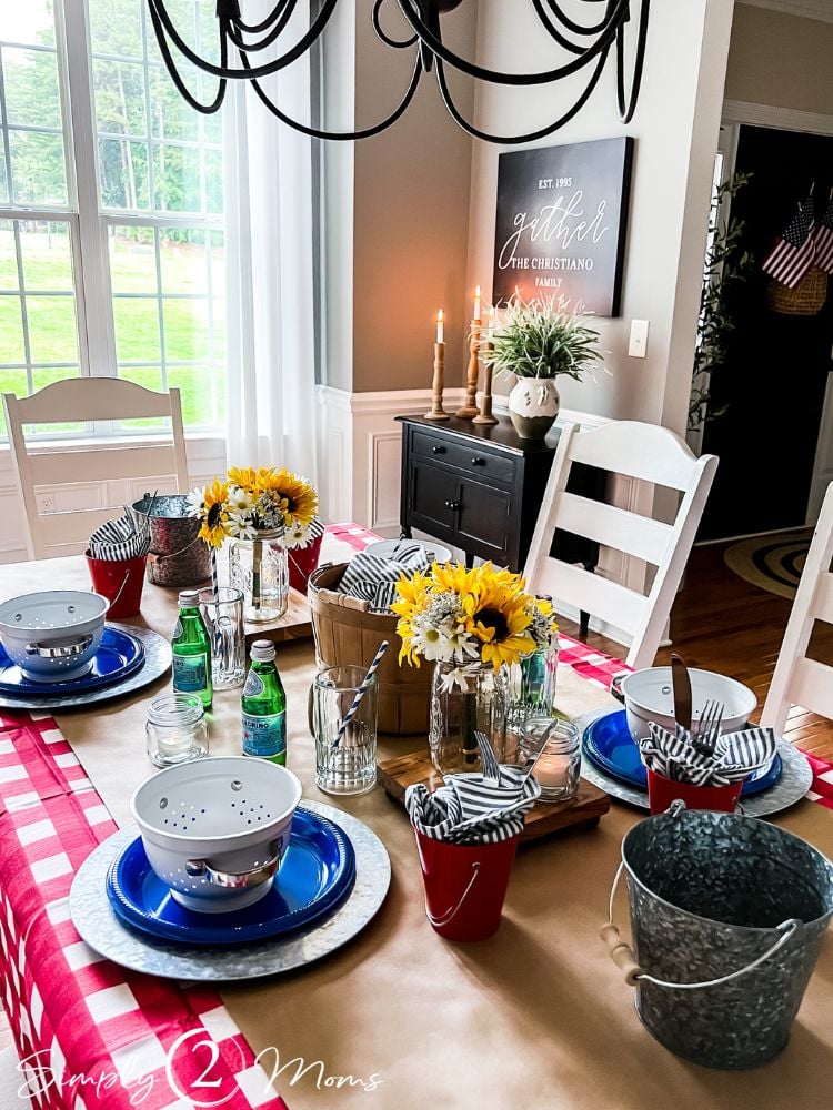 Table lined with brown paper with four settings for a low country boil. Decorated with sunflowers and striped linen napkins