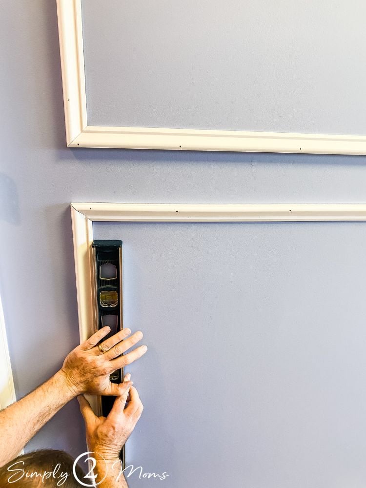 Level being held against pieces of trim being used for picture frame moulding