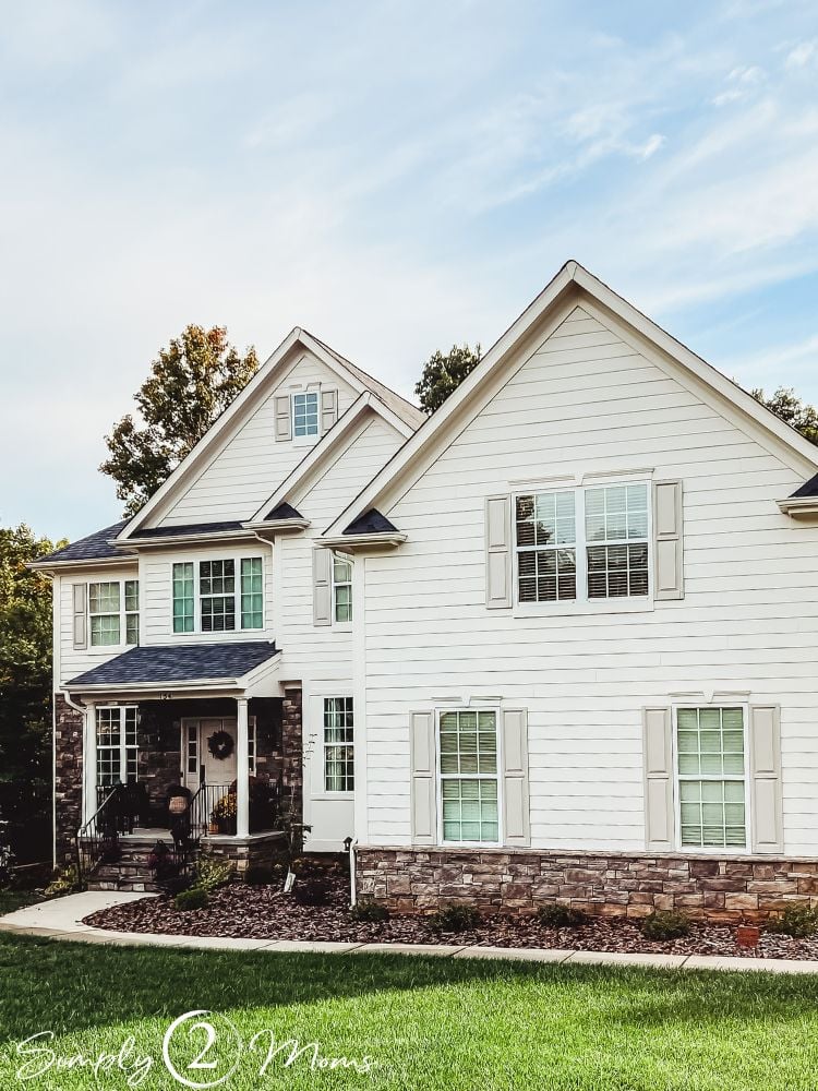 Front exterior house with Shoji White Hardie Plank siding stone foundation and Anew Gray shutters.