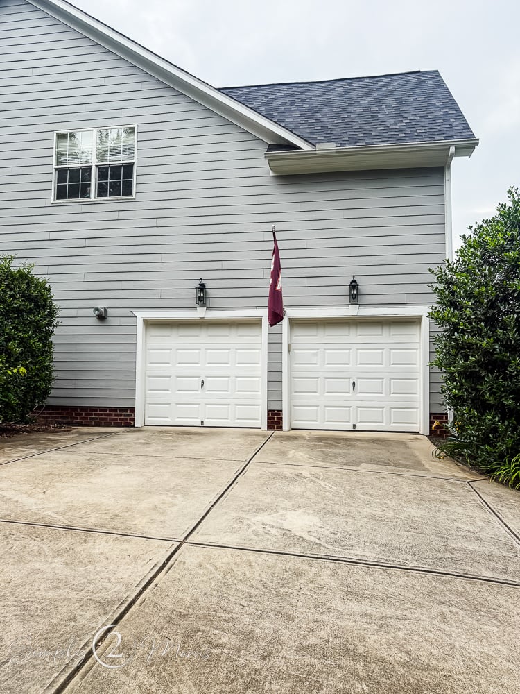 Exterior of a house with side load garage and builder basic garage doors.