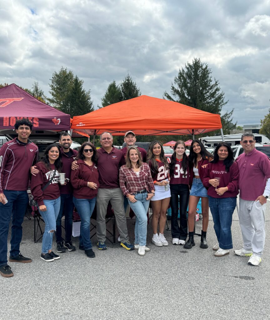 Large family group gathered under tents at a Virginia Tech tailgate, dressed in team colors and celebrating college football together.
