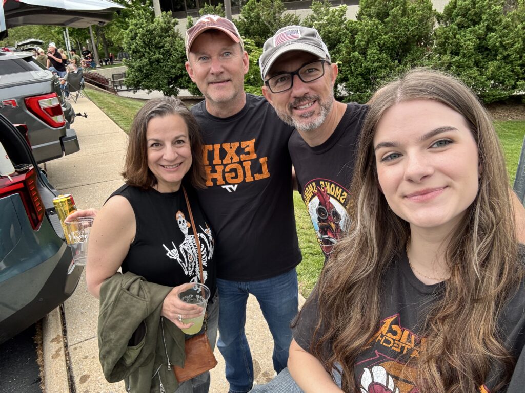 Family enjoying a Metallica concert tailgate, smiling together in band shirts before the live show experience.