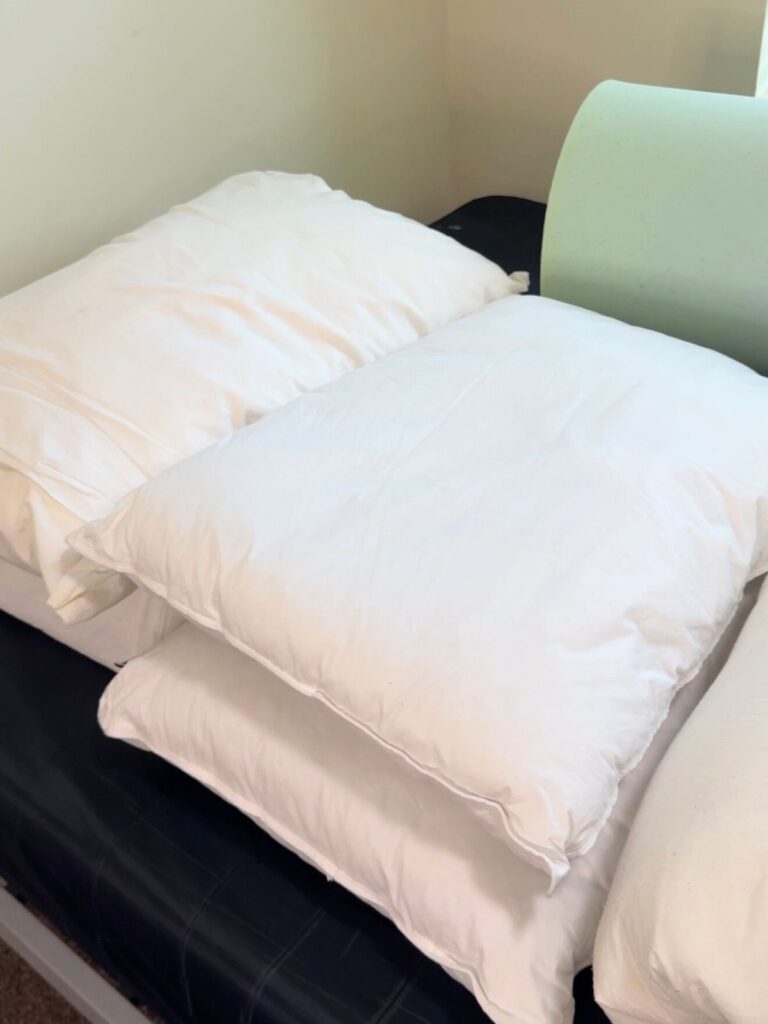 White pillows stacked on a dorm bed