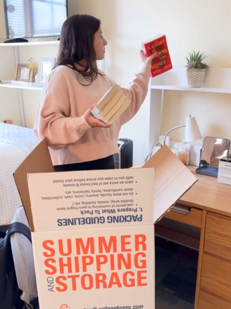 Student packing dorm desk into College Boxes by U-Haul box.
